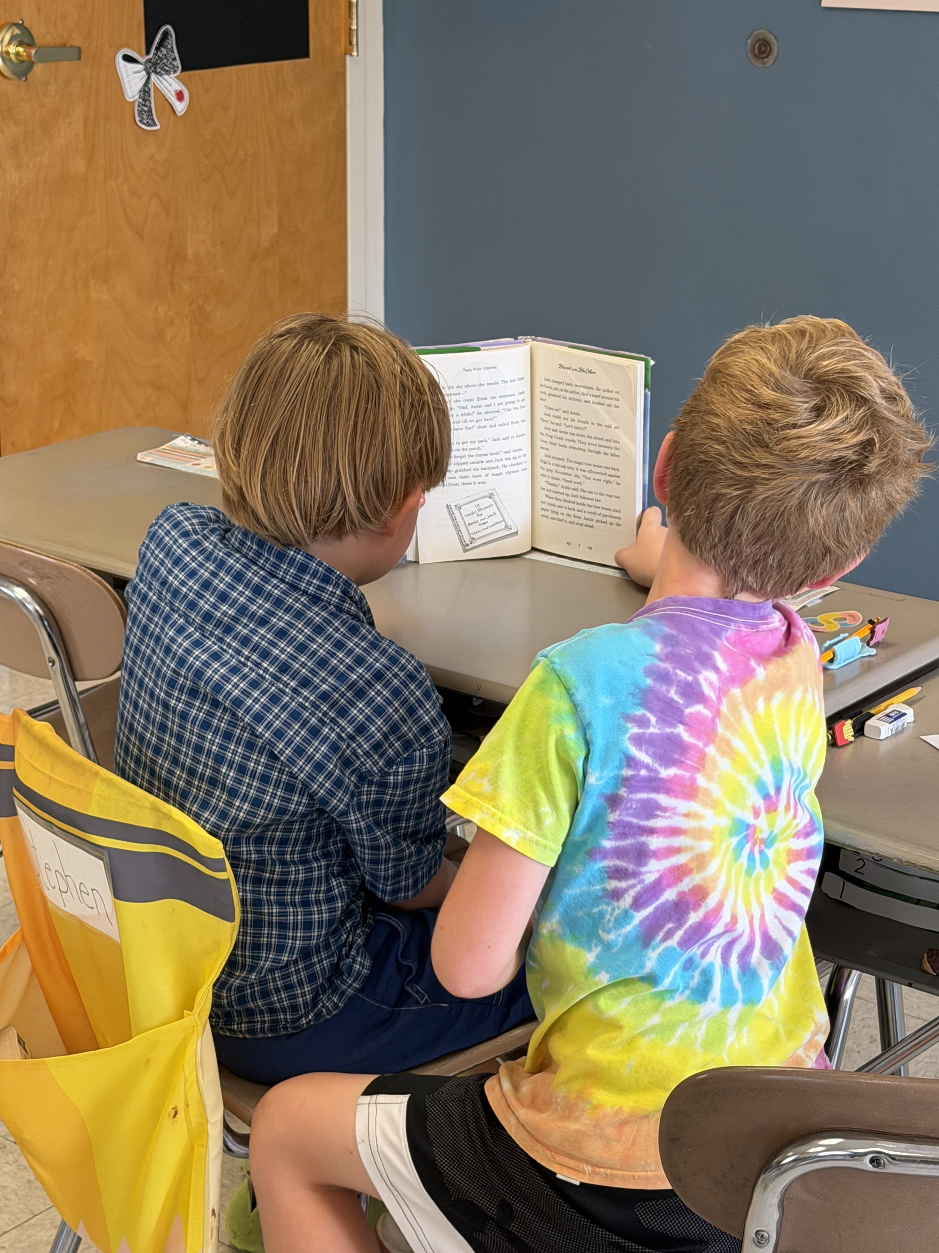 Students sharing a book in the PBCS library